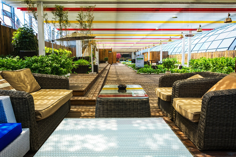 Cobertura de vidro sobre amplo ambiente com sofas, flores